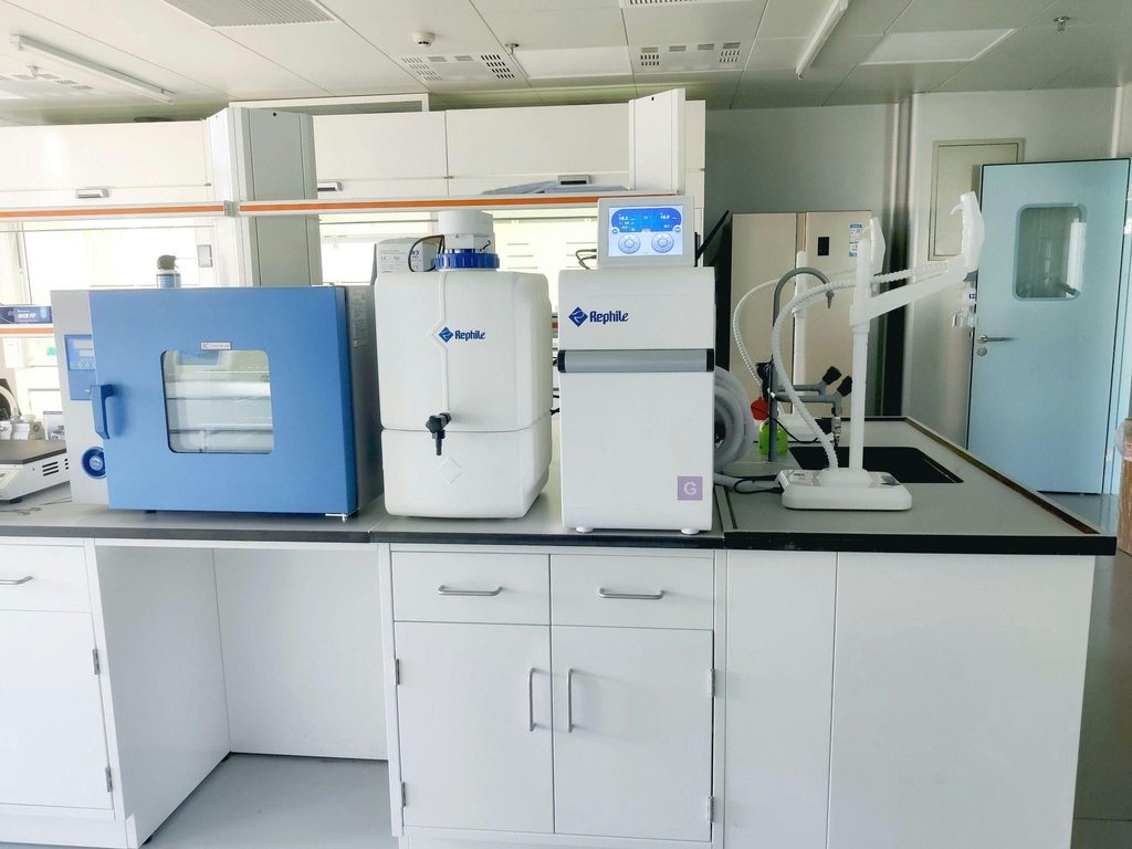 Laboratory bench with a blue unit, two white machines and a pipette stand, ready for transport.